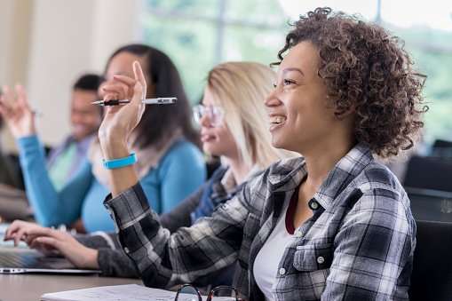 Confident Female College Students Raise Hands In Class ...