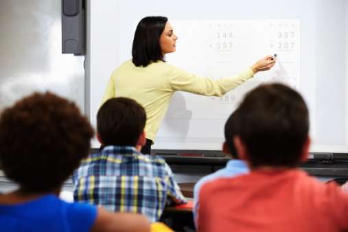 Teacher Standing In Class Using Interactive Whiteboard ...